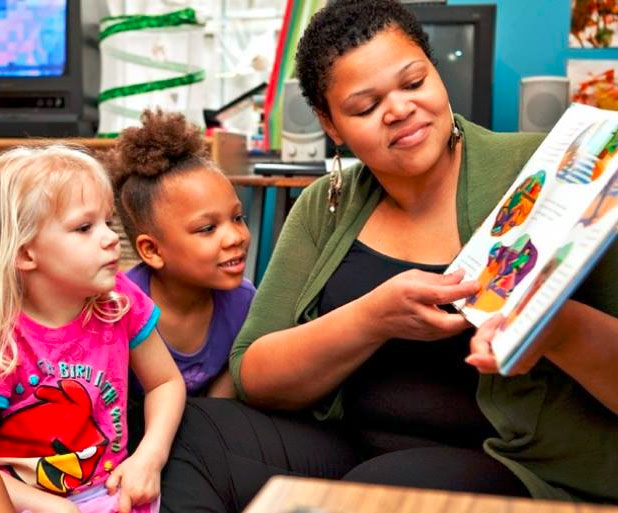 Young little girls paying attention to the teacher showing them pictures from a storytelling book at a Christian Preschool & Daycare Serving Loganville, GA