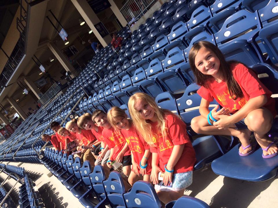 Group of young kids enjoying at the stadium wearing red school themed shirt at a Christian Preschool & Daycare Serving Loganville, GA