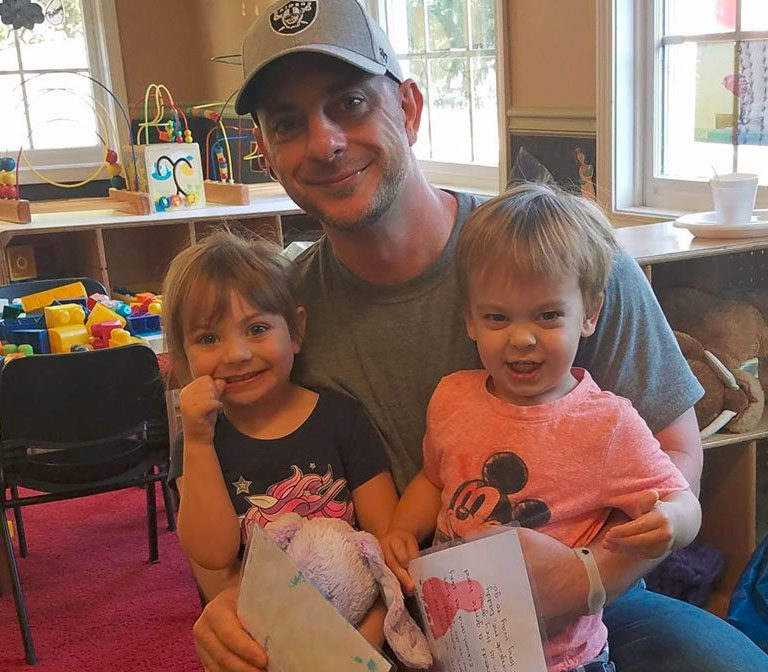 Happy Daddy and two little kiddos each wearing a Disney inspired shirt at a Christian Preschool & Daycare Serving Loganville, GA