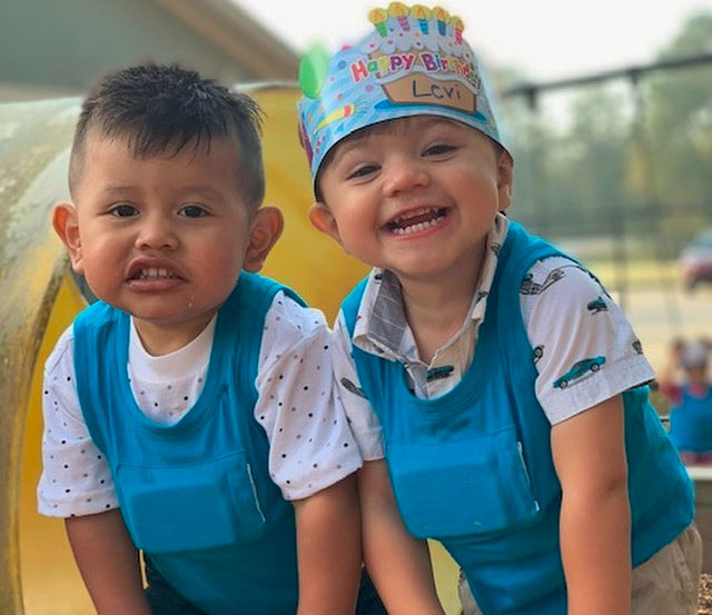 Happy little nursery boys enjoying birthday celebration wearing a blue clothes and one wearing birthday hat