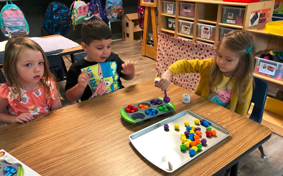 Preschool kids playing on the table some colored balls at a Christian Preschool & Daycare Serving Loganville, GA