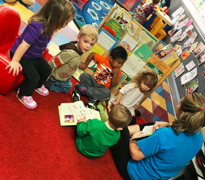 Toddlers listening attentively to the teacher reading books and storytelling at a Christian Preschool & Daycare Serving Loganville, GA