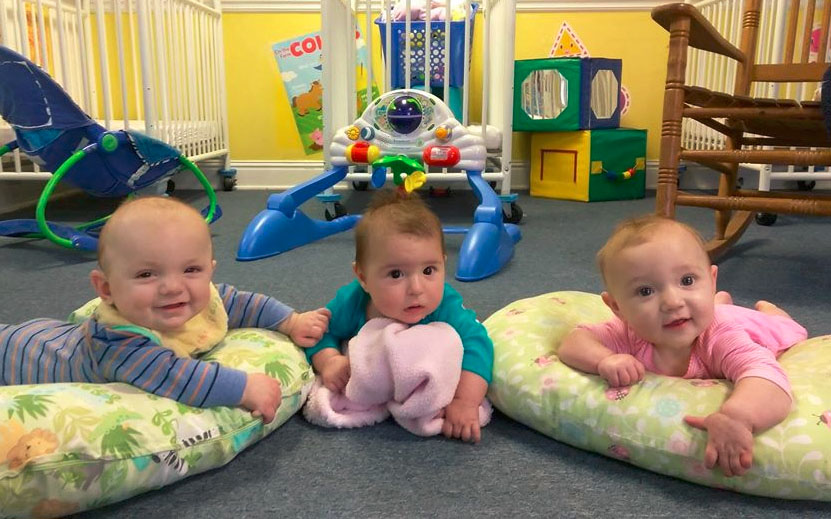 Adorable babies smiling on a pillow bed at a Christian Preschool & Daycare Serving Loganville, GA